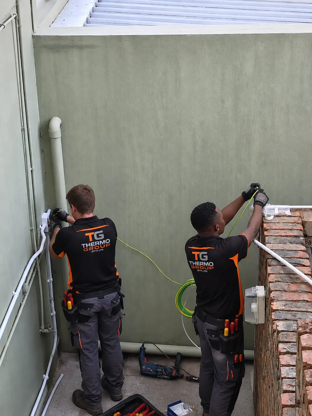 Thermo Group technicians installing electrical cabling and conduit in Bergvliet