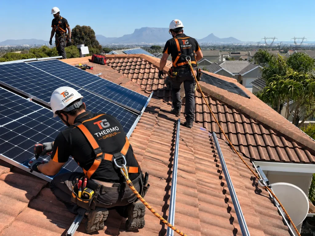 Thermo Group solar panel installation team on a Blouberg home rooftop with Table Mountain in the background, Cape Town