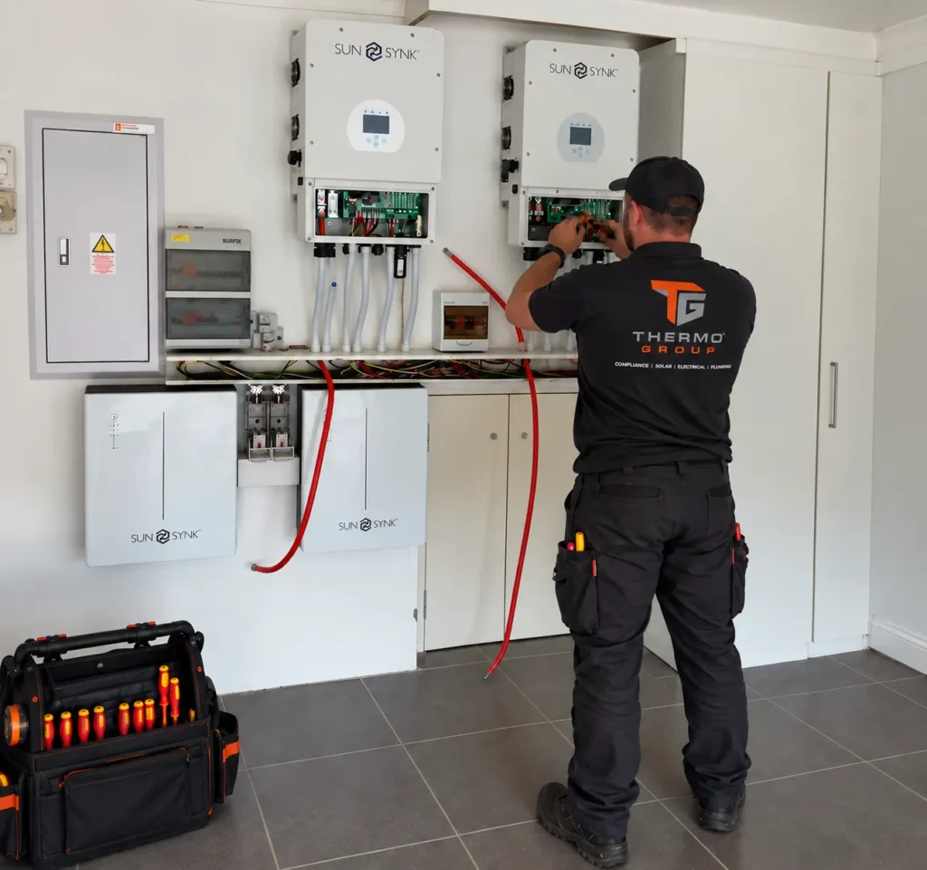 Thermo Group technician installing a solar inverter and battery system in Hout Bay